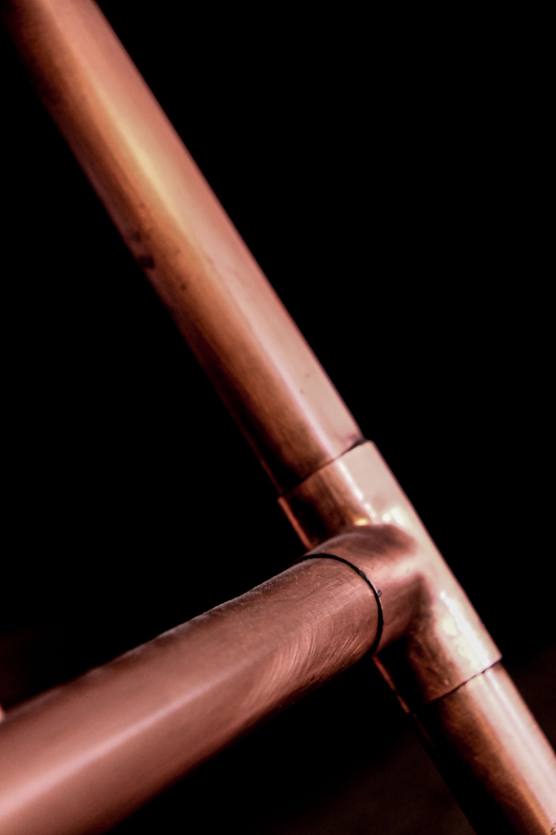 Copper pipe joint against a black background